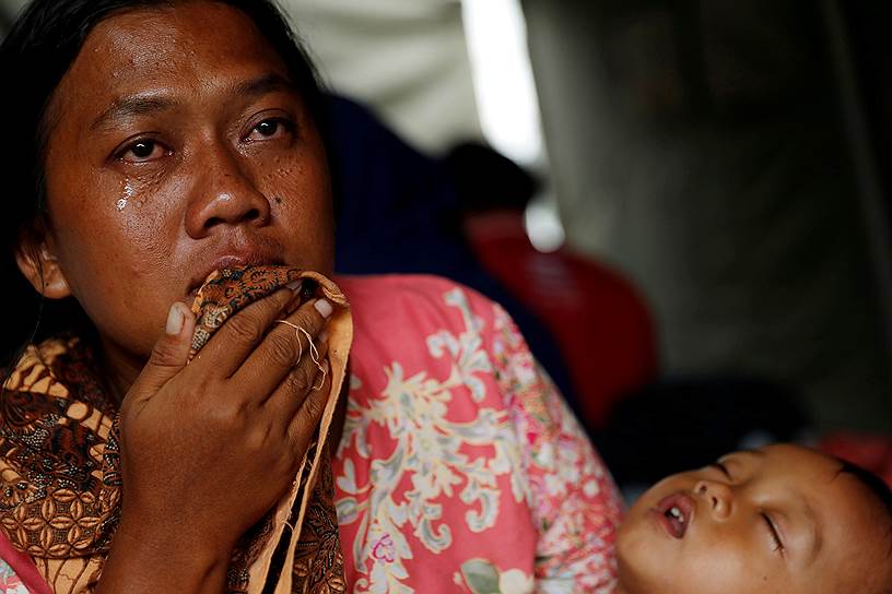 Провинция Бантен, Индонезия. Женщина с ребенком в центре временного размещения после цунами 
