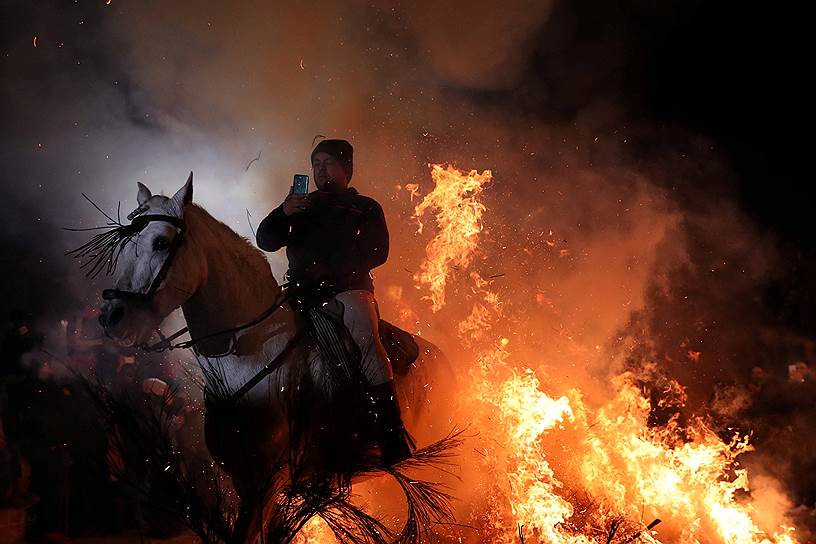 Сан-Бартоломе-де-Пинарес, Испания. Всадник на лошади прыгает через костер во время фестиваля Luminarias