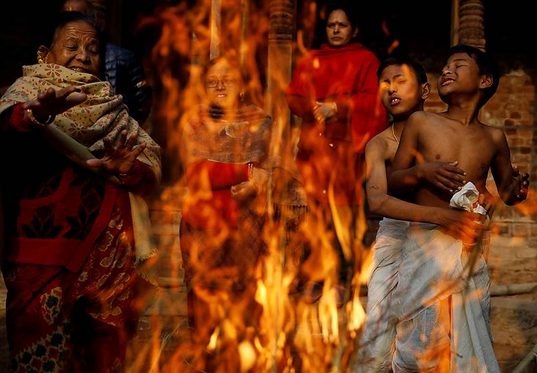 Бхактапур, Непал. Верующие греются у огня во время религиозного фестиваля Свастхани Брата Катха