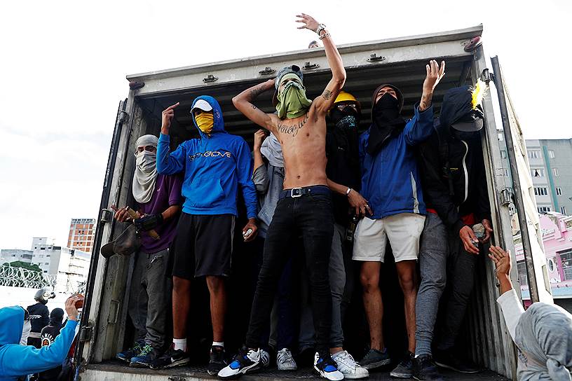 Демонстранты на грузовике во время акции протеста в Каракасе