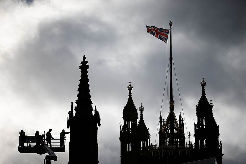 Лондон, Великобритания. Рабочие с помощью крана осматривают крышу здания парламента