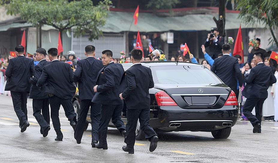 Донг-Данг, Вьетнам. Телохранители лидера КНДР Ким Чен Ына бегут рядом с его лимузином