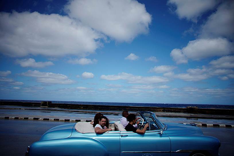 Гавана, Куба. Туристы катаются на старом автомобиле