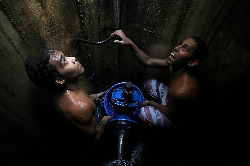 Каракас, Венесуэла. Местные жители набирают воду из подземного хранилища