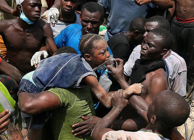 Лагос, Нигерия. Спасатели выносят ребенка из обвалившейся школы