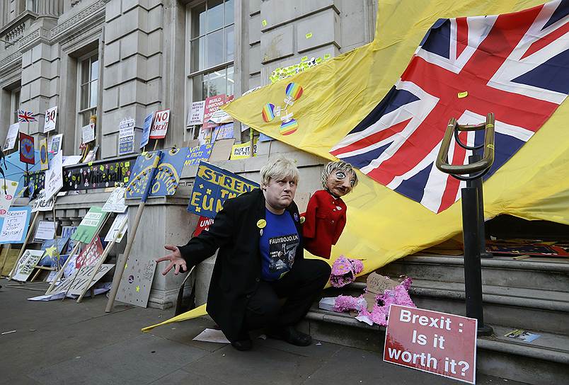 Демонстрант, похожий на Бориса Джонсона, держит марионетку в виде премьер-министра Терезы Мэй
