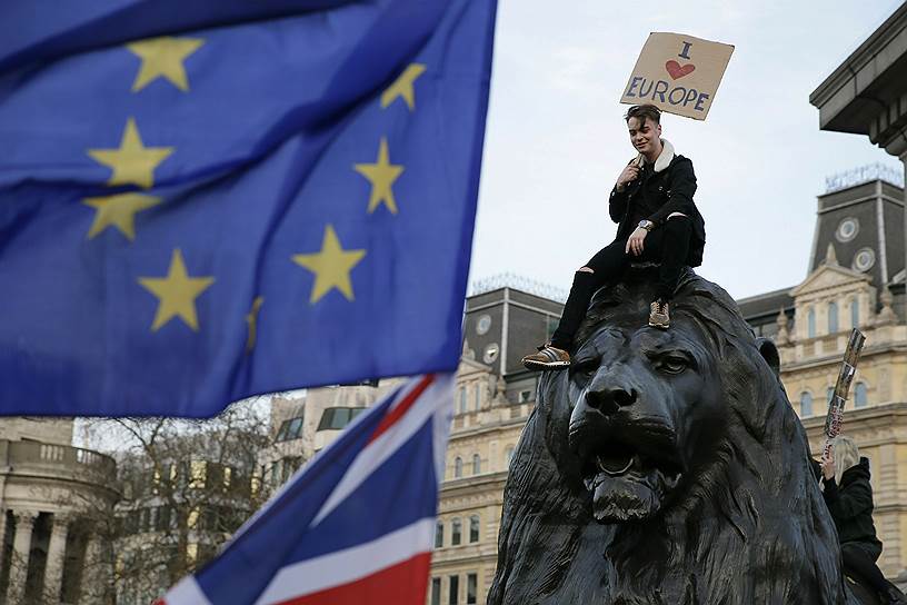 Демонстрант сидит на одном из львов на Трафальгарской площади во время марша протеста против «Брексита»