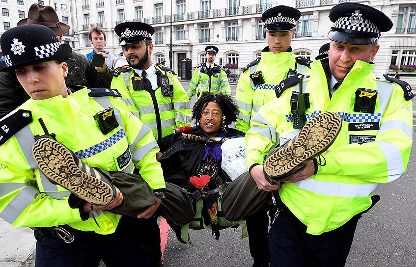 Лондон, Великобритания. Сотрудники полиции несут задержанного демонстранта 