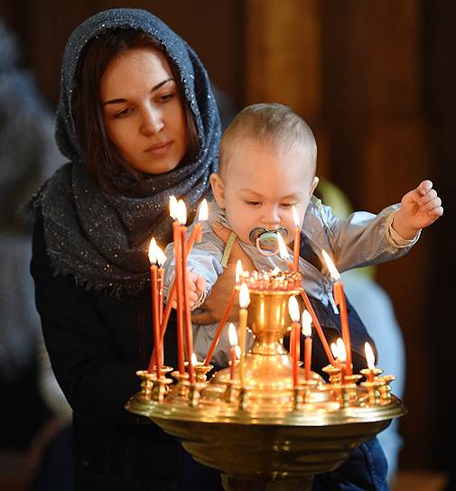 Село Филипповское, Владимирская область. Женщина с ребенком ставит свечу в храме