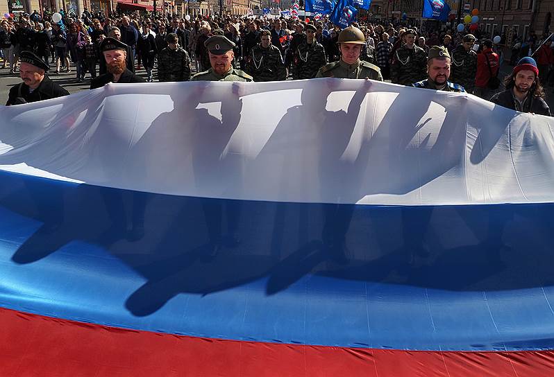 Участники первомайского шествия несут российский флаг