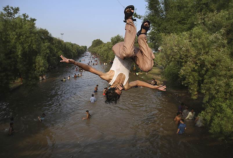 Лахор, Пакистан. Люди пытаются спастись от аномальной жары в городском канале
