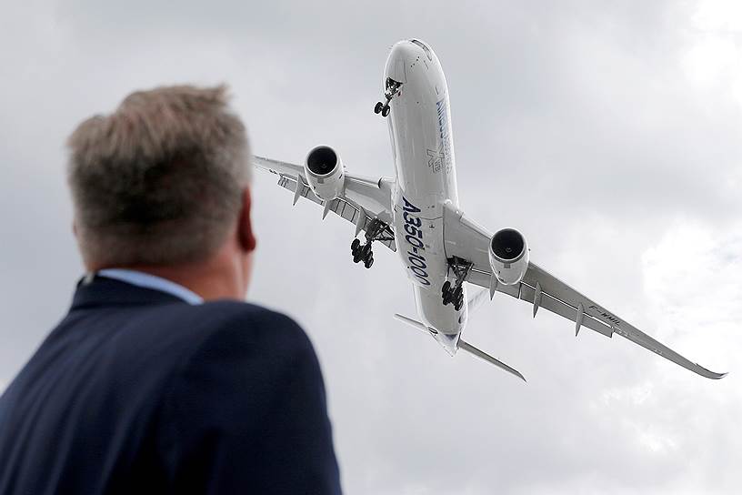 Посетитель наблюдает за  демонстрационным полетом Airbus A350-1000