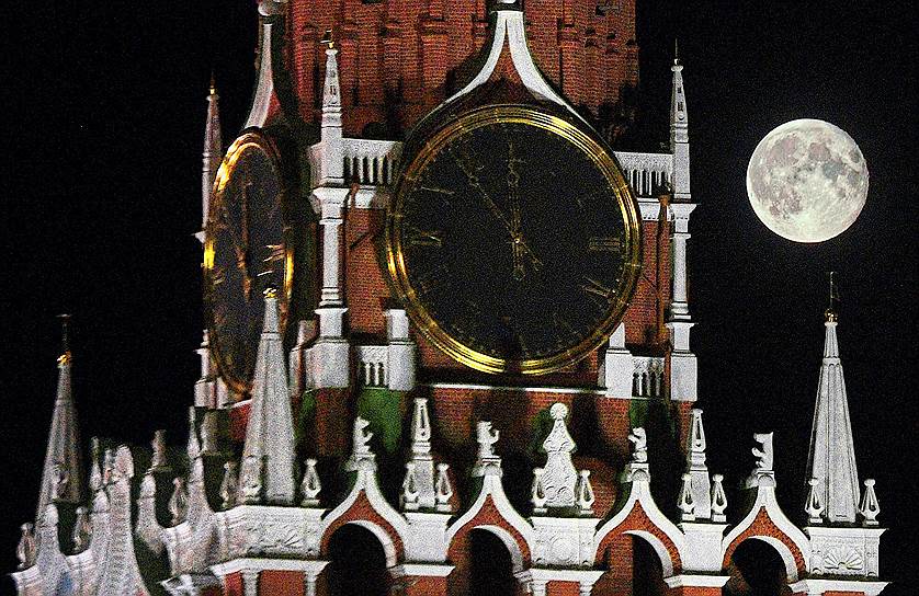 Москва, Россия. Часы на Спасской башне Кремля во время полнолуния
