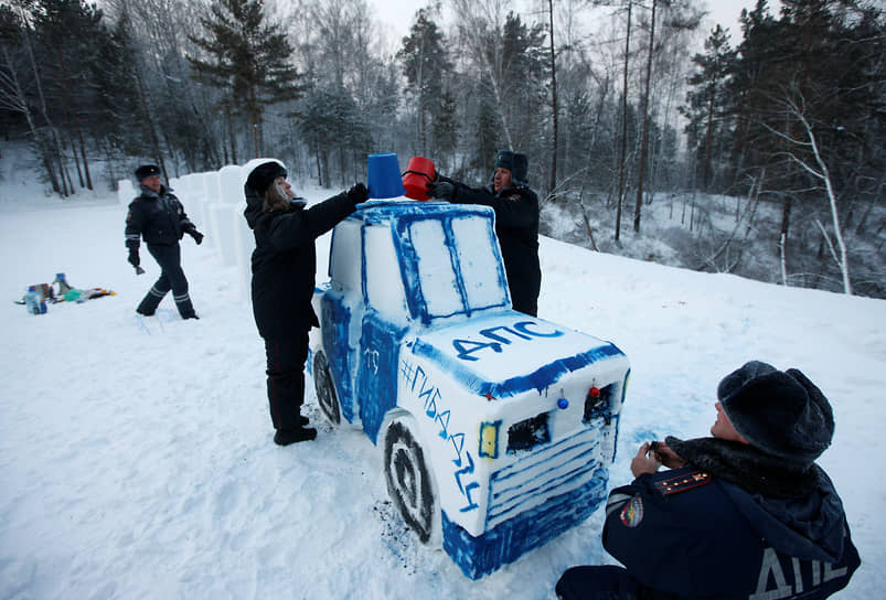 Сотрудники ГИБДД лепят патрульный автомобиль из снега