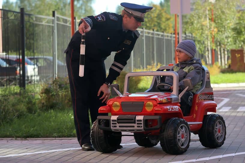 Гаишник учит ребенка правилам дорожного движения