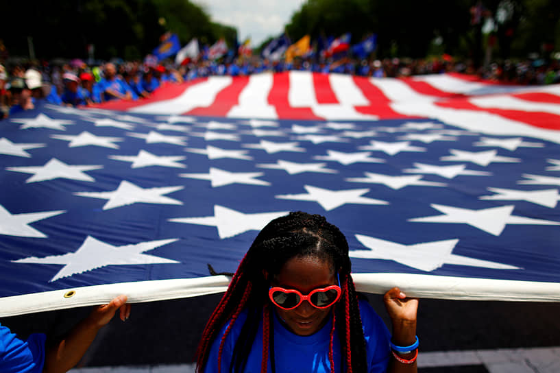 Вашингтон, округ Колумбия. Девушка несет американский флаг