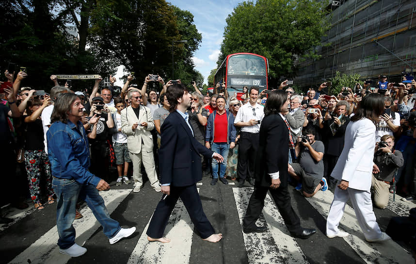 Лондон, Великобритания. Прохожие фотографируют, как участники кавер-группы The Beatles переходят дорогу по пешеходному переходу на Эбби-Роуд