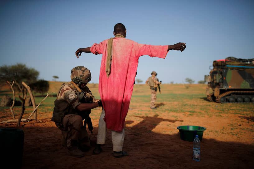 Мали. Французский солдат из иностранного легиона, патрулирующего регион, обыскивает мужчину