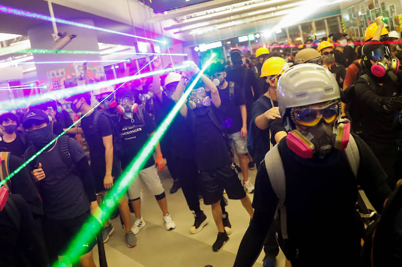Гонконг. Протестующие в метро под лазерами, нейтрализующими полицейские камеры наблюдения
