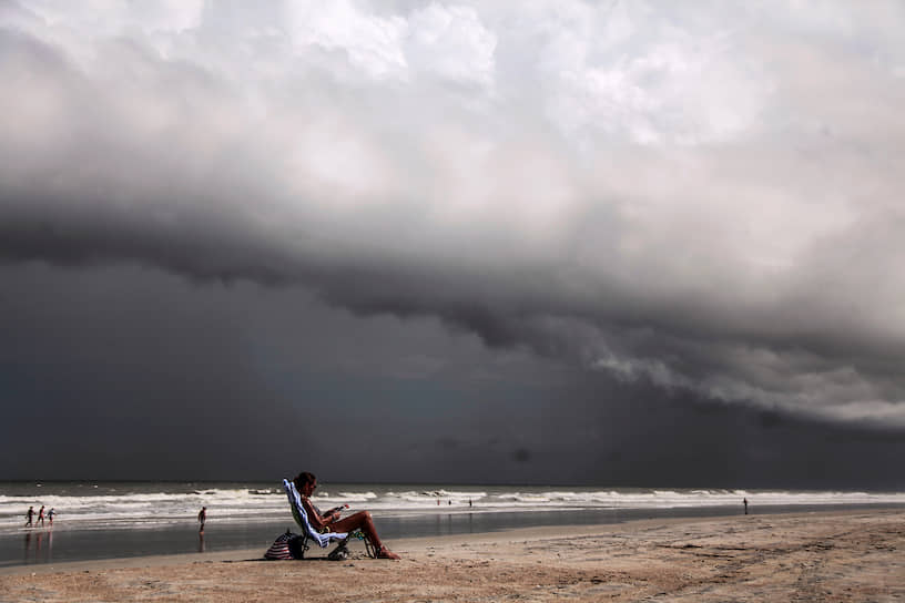 Остров Амилия, США. Местная жительница на фоне тропического урагана Дориан, обрушившегося на побережье штата Флорида  