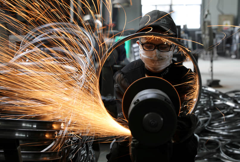 Чжэцзян, Китай. Рабочий сваривает стальной обод велосипеда на заводе по производству спортивного инвентаря