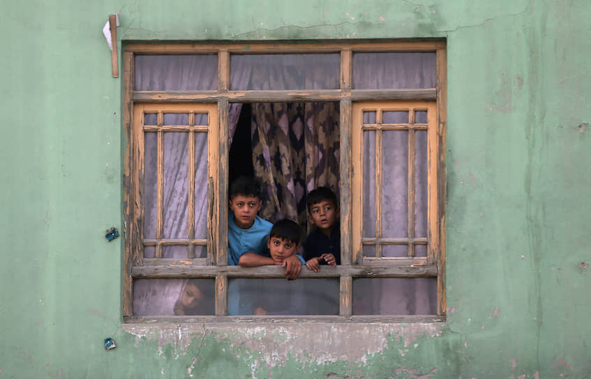 Кабул, Афганистан. Дети смотрят на место взрыва из разбитого окна