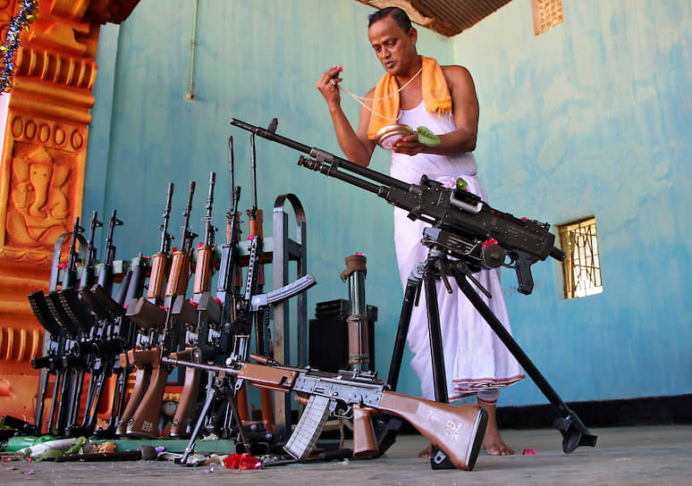 Агартала, Индия. Индуистский священнослужитель проводит религиозный обряд с оружием