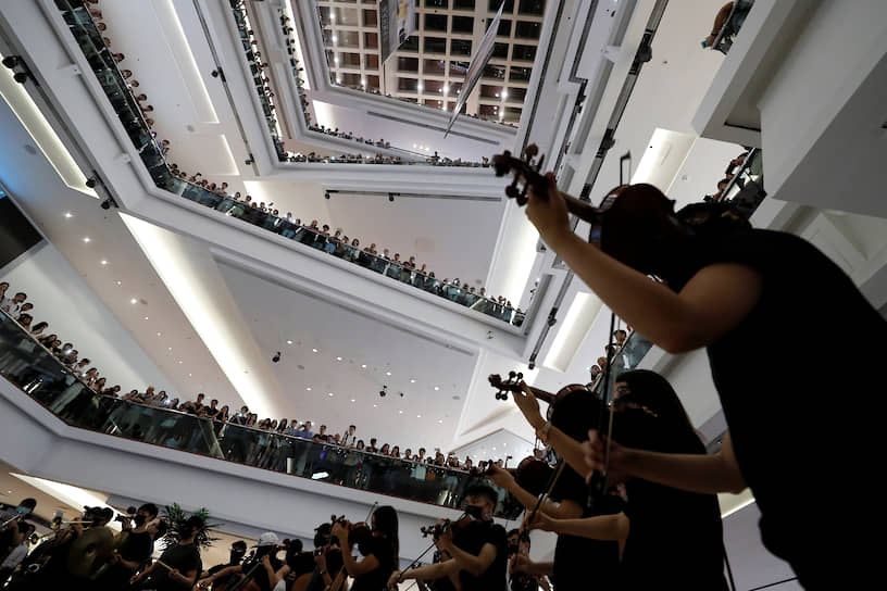 Гонконг, Китай. Группа музыкантов исполняет протестную песню в торговом центре