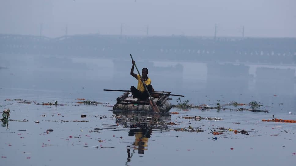 Дели, Индия. Мужчина переплывает реку на самодельной лодке 