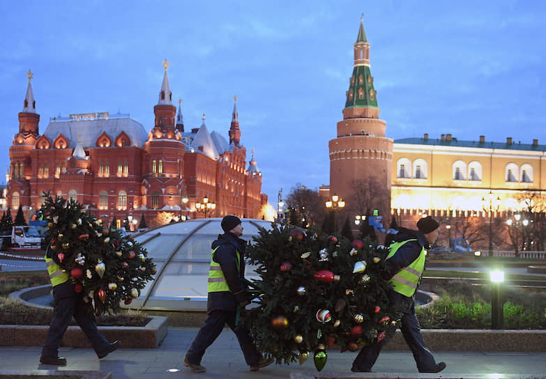 Москва, Россия. Сотрудники муниципальных служб несут новогодние украшения на Манежной площади