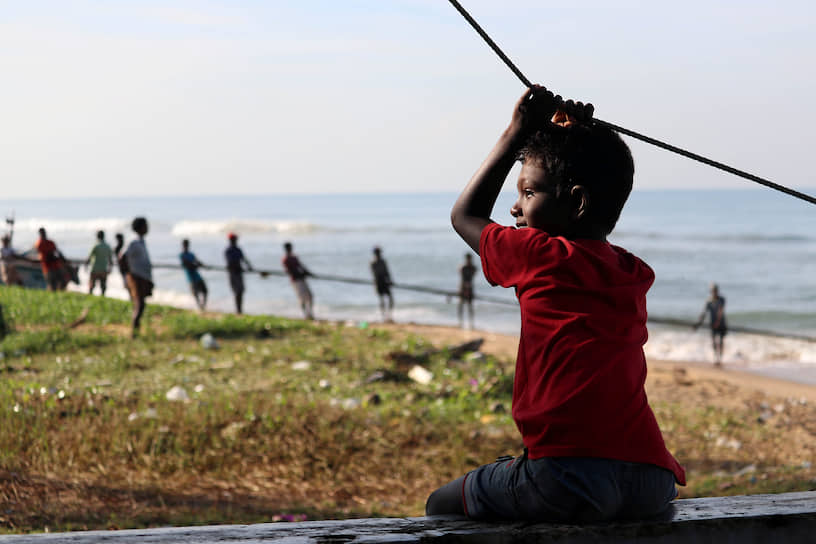 Коломбо, Шри-Ланка. Мальчик наблюдает за работой рыбаков