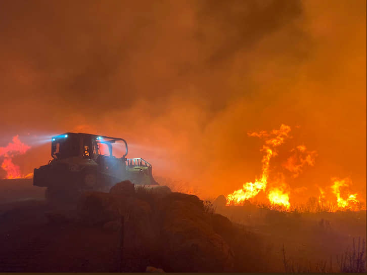 Штат Калифорния, США. Бульдозер на фоне лесного пожара