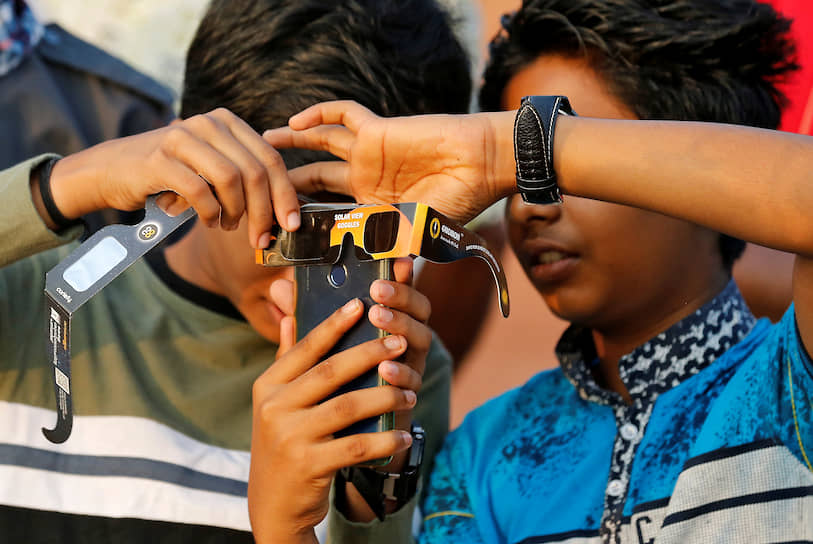 Черуватур, Индия. Мальчики пытаются снять на телефон солнечное затмение