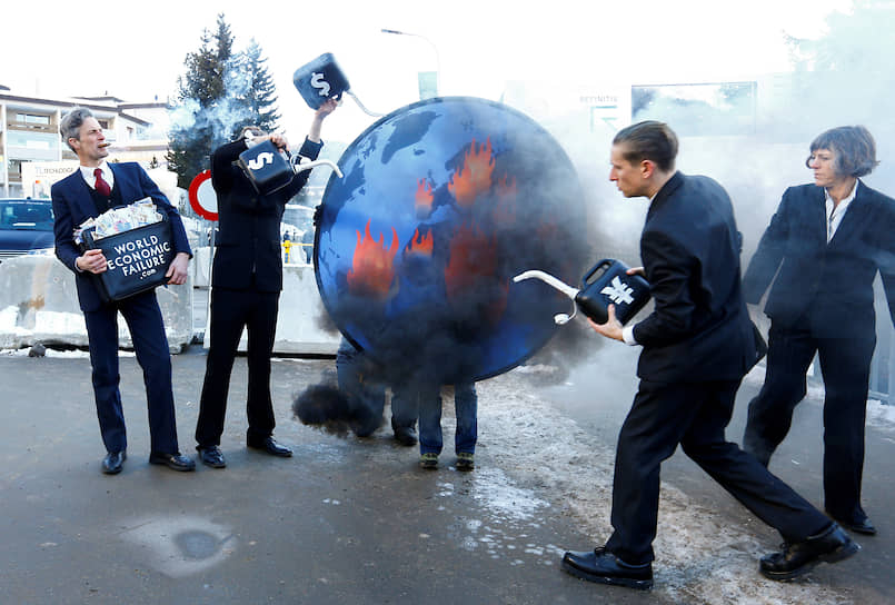 Участники акции протеста в Давосе поджигают глобус