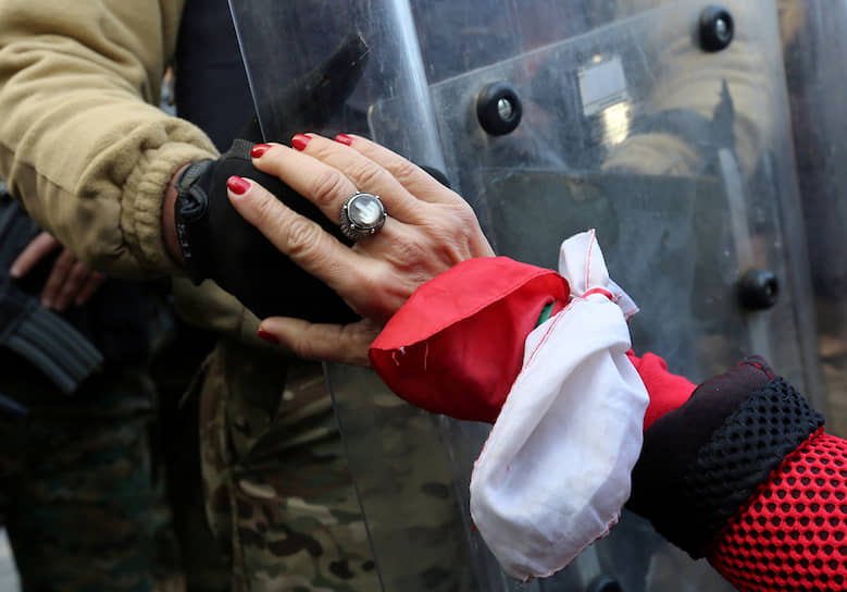 Бейрут, Ливан. Участница антиправительственной акции держит за руку солдата 