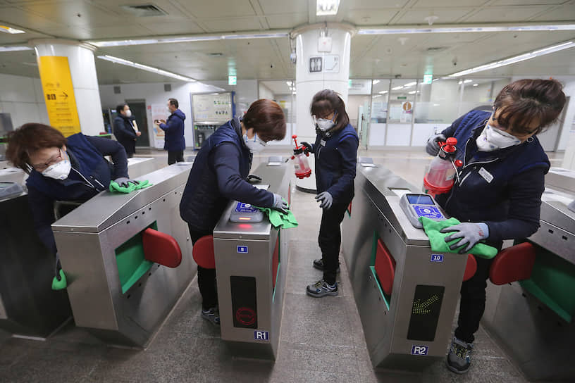 Сотрудники аэропорта дезинфицируют поверхности на станции метро в Сеуле, Южная Корея 