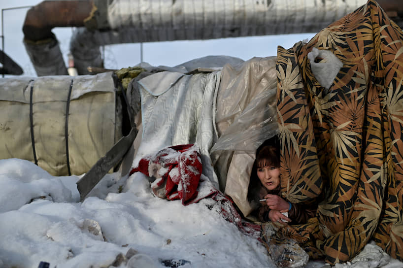 Омск. Бездомная женщина у теплотрассы