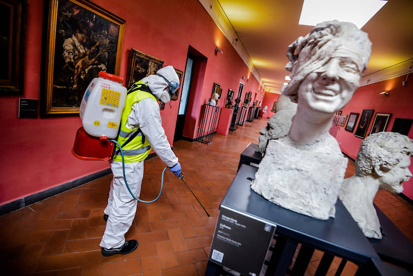 Неаполь, Италия. Рабочий распыляет дезинфицирующее средство в музее