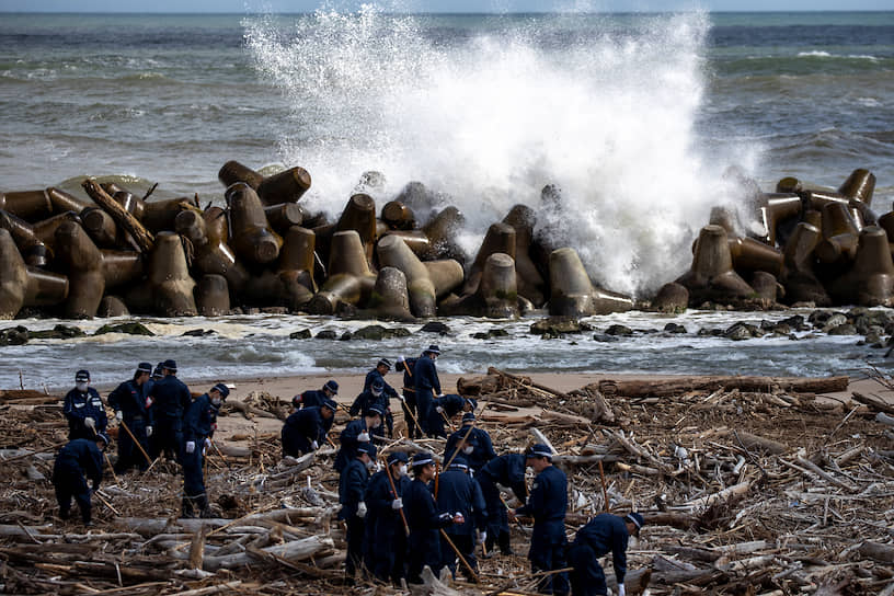 Намиэ, Япония. Сотрудники полиции принимают участие в операции по поиску останков людей, пропавших без вести после землетрясения и цунами 11 марта 2011 года