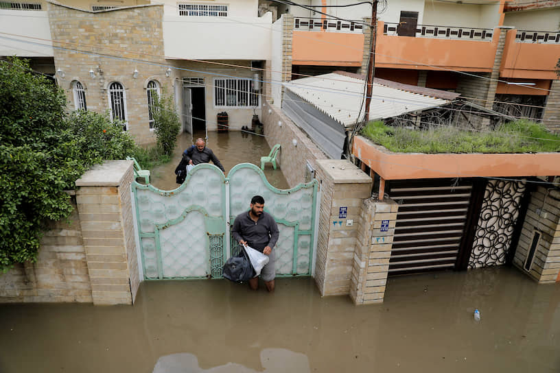 Мосул, Ирак. Местные жители около затопленного после сильных дождей дома