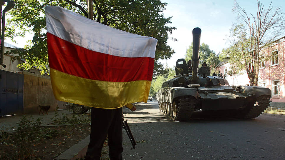 Грузино-югоосетинский конфликт. Танки 58-й армии России входят в город Цхинвал. Местный житель приветствует их с флагом Южной Осетии 