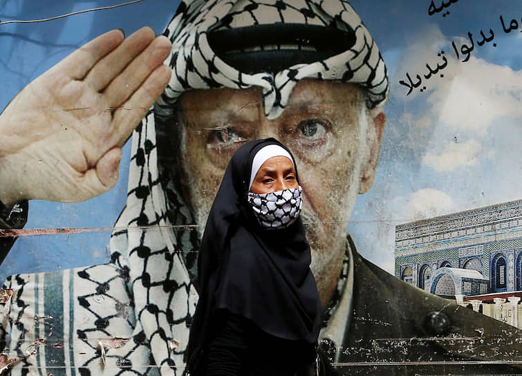 Бейрут, Ливан. Женщина на фоне плаката с изображением бывшего палестинского лидера Ясира Арафата