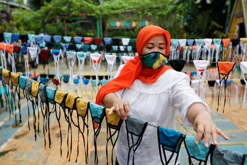 Тангеранг, Индонезия. Женщина вывесила сушиться защитные маски 