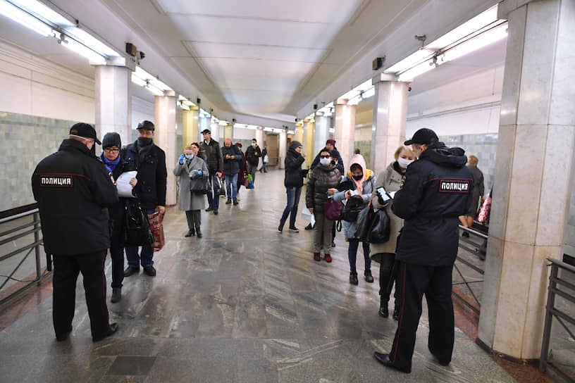 Пассажиры метро показывают электронные пропуска сотрудникам полиции на станции метро «Сокольники» 