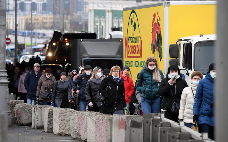 Люди идут вдоль автомобильной пробки на въезде в Москву