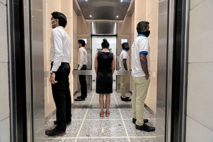 Коломбо, Шри-Ланка. Люди показывают, как нужно соблюдать дистанцию в лифте
