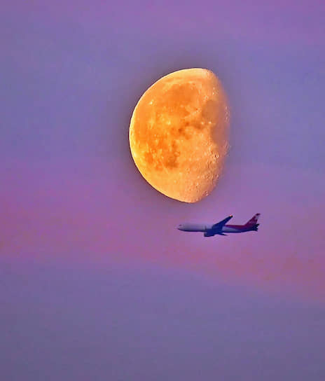 Москва. Самолет в небе на фоне Луны 