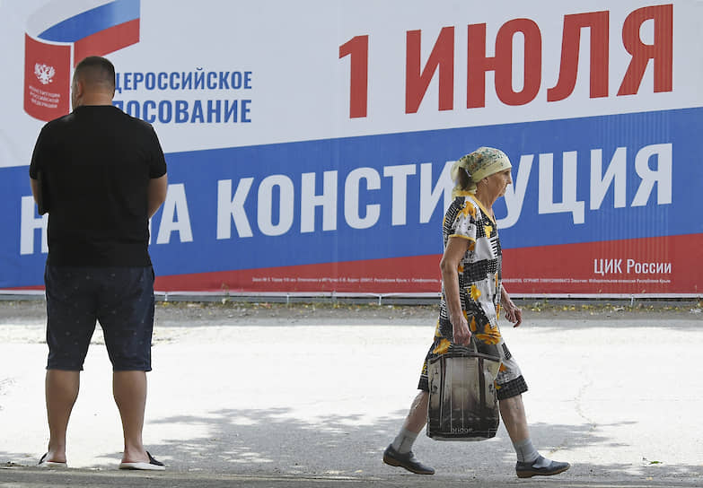 Москва. Прохожие на фоне плаката, посвященного всероссийскому голосованию по поправкам в Конституцию