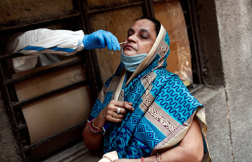Нью-Дели, Индия. Медработник берет у женщины мазок на коронавирус