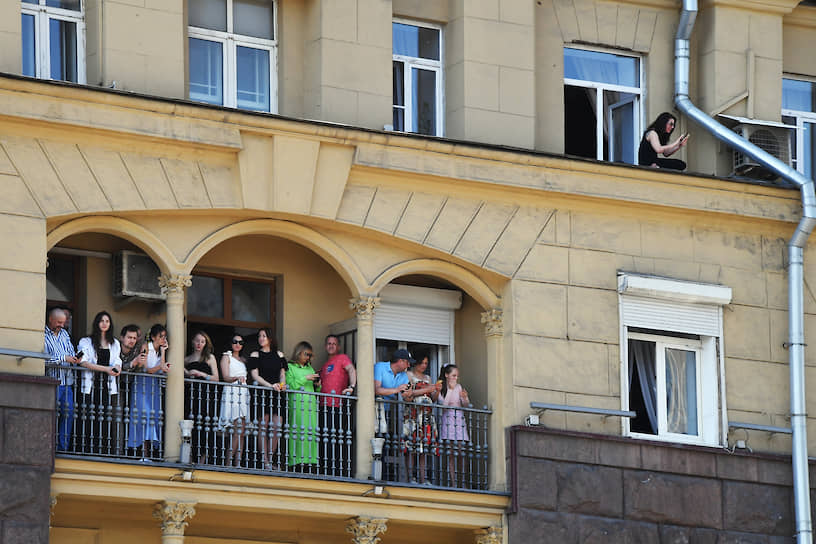 Зрители наблюдают с балконов за проходом военной техники по Москве